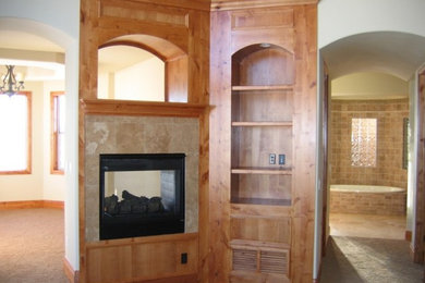 Inspiration for a mid-sized rustic master carpeted and brown floor bedroom remodel in Denver with white walls, a two-sided fireplace and a tile fireplace