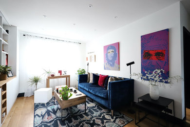 Ejemplo de salón abierto minimalista grande con suelo de madera clara y pared multimedia