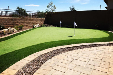This is an example of a mid-sized contemporary drought-tolerant backyard stone landscaping in Phoenix.