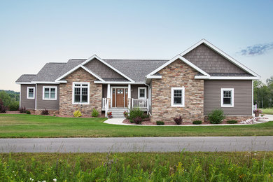 Large arts and crafts one-story mixed siding exterior home photo in Other