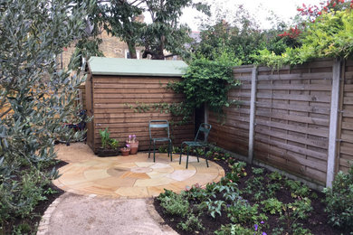Design ideas for a small mediterranean backyard partial sun xeriscape for summer in London with a garden path and natural stone pavers.