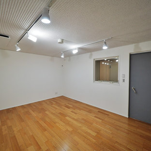 Idées déco pour une salle de cinéma scandinave de taille moyenne avec un mur blanc, un sol en contreplaqué et un sol marron.