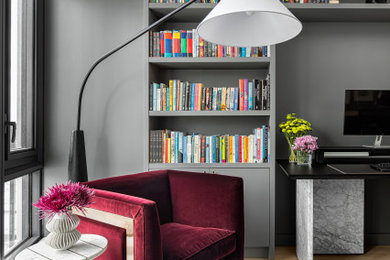トロントにある高級な広いコンテンポラリースタイルのおしゃれなホームオフィス・書斎 (ライブラリー、グレーの壁、淡色無垢フローリング、自立型机、ベージュの床) の写真