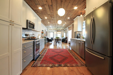 Arts and crafts galley medium tone wood floor kitchen photo in Houston with a single-bowl sink, shaker cabinets, gray cabinets, quartz countertops, white backsplash, subway tile backsplash and stainless steel appliances