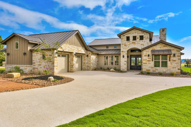 Mid-sized trendy two-story stone house exterior photo in Dallas with a metal roof and a brown roof