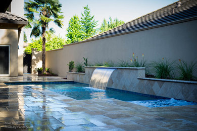 Pool fountain - mid-sized contemporary backyard stone and rectangular pool fountain idea in Sacramento