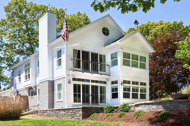 Design ideas for a mid-sized traditional two-storey white house exterior in New York with wood siding, a gable roof, a shingle roof, a grey roof and board and batten siding.