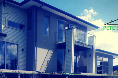 Photo of a mid-sized modern two-storey brown house exterior in Christchurch with wood siding, a hip roof and a metal roof.