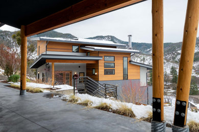 Inspiration for a mid-sized contemporary multicolored mixed siding house exterior remodel in Other with a shed roof and a metal roof