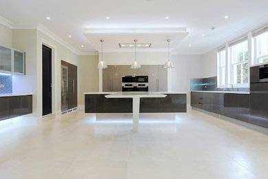 Photo of an expansive contemporary u-shaped open plan kitchen in London with an integrated sink, flat-panel cabinets, dark wood cabinets, solid surface benchtops, metallic splashback, glass sheet splashback, panelled appliances, porcelain floors and with island.