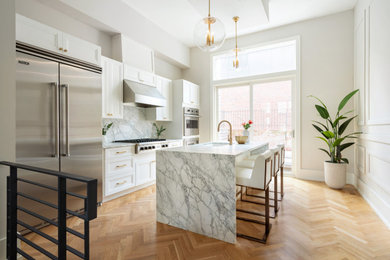 Idéer för att renovera ett mellanstort vintage grå linjärt grått kök och matrum, med en undermonterad diskho, skåp i shakerstil, vita skåp, marmorbänkskiva, grått stänkskydd, stänkskydd i marmor, rostfria vitvaror, ljust trägolv och en köksö