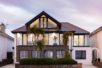Design ideas for a large and white contemporary render and front house exterior in Other with three floors, a hip roof, a tiled roof, a black roof and shiplap cladding.