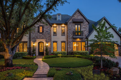 Large elegant two-story stone exterior home photo in Houston with a hip roof