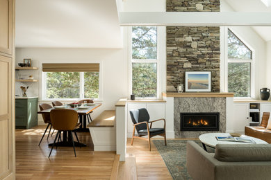 Mid-sized transitional open concept light wood floor and exposed beam living room photo in Burlington with white walls, a standard fireplace, a stone fireplace and a wall-mounted tv
