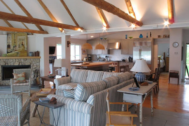 Inspiration for a mid-sized coastal open concept medium tone wood floor family room remodel in Other with white walls, a corner fireplace, a stone fireplace and a wall-mounted tv