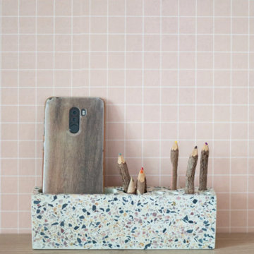 Petits rangements en terrazzo et papier peint rose à petits carreaux