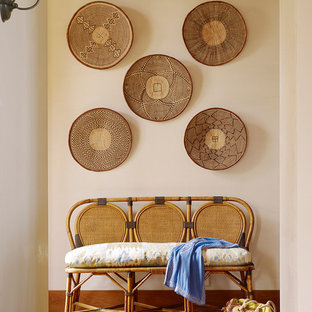 Foto på en tropisk hall, med vita väggar och mellanmörkt trägolv