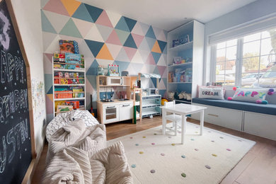 Design ideas for a large classic open plan games room in Kent with a game room, multi-coloured walls, laminate floors, a wall mounted tv, wallpapered walls and a feature wall.