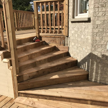 Wide pressure-treated stairs between two deck levels in Markham