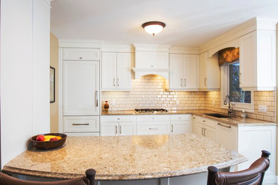 This is an example of a mid-sized traditional l-shaped separate kitchen in Toronto with an undermount sink, flat-panel cabinets, white cabinets, quartz benchtops, beige splashback, ceramic splashback, panelled appliances, ceramic floors and a peninsula.