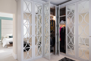 Photo of a modern dressing room in Dorset with glass-front cabinets and white cabinets.