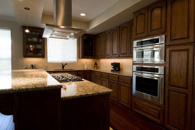 Inspiration for a mid-sized transitional l-shaped dark wood floor open concept kitchen remodel in Austin with an undermount sink, raised-panel cabinets, dark wood cabinets, granite countertops, beige backsplash, ceramic backsplash, stainless steel appliances and an island