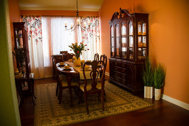 This is an example of a transitional dining room in Houston with pink walls and medium hardwood floors.