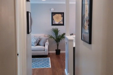Example of a small trendy light wood floor hallway design in Other with gray walls