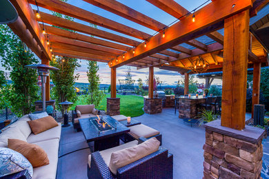 Mid-sized traditional backyard patio in Calgary with a fire feature and a pergola.