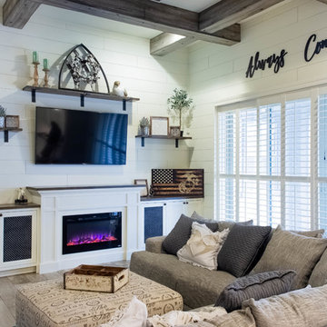 White entertainment center with raised fireplace, mounted shelves