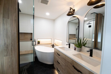 Example of a country master white tile and porcelain tile porcelain tile, black floor and double-sink bathroom design in Edmonton with flat-panel cabinets, medium tone wood cabinets, white walls, an undermount sink, quartz countertops, a hinged shower door, white countertops and a built-in vanity