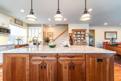 Inspiration for a large transitional l-shaped light wood floor open concept kitchen remodel in Bridgeport with recessed-panel cabinets, medium tone wood cabinets, quartz countertops, stainless steel appliances, an island and beige countertops