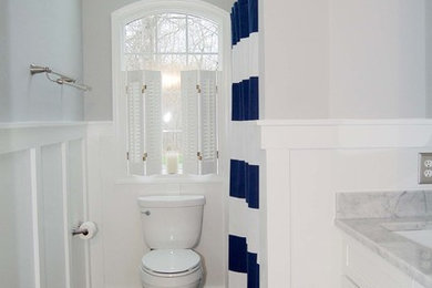 Inredning av ett klassiskt litet badrum för barn, med skåp i shakerstil, vita skåp, marmorbänkskiva, en dusch/badkar-kombination, en toalettstol med separat cisternkåpa, grå väggar, klinkergolv i keramik och ett undermonterad handfat
