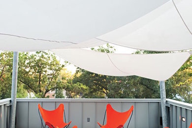 Inspiration for a mid-sized contemporary side yard patio remodel in Chicago with decking and an awning
