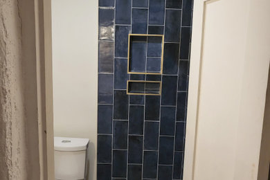Ejemplo de cuarto de baño moderno con ducha esquinera, sanitario de dos piezas, baldosas y/o azulejos azules, suelo de baldosas de cerámica y suelo marrón