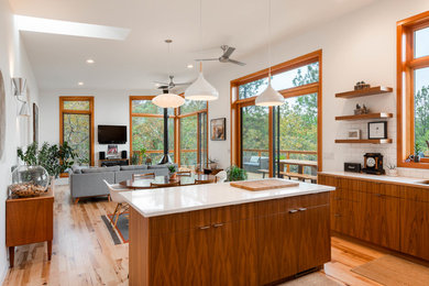 Inspiration for a mid-sized contemporary l-shaped medium tone wood floor and brown floor open concept kitchen remodel in Other with flat-panel cabinets, medium tone wood cabinets, white backsplash, subway tile backsplash, stainless steel appliances, an island, white countertops, an undermount sink and quartzite countertops