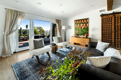 Immagine di un soggiorno bohémian aperto e di medie dimensioni con sala formale, pareti bianche, parquet chiaro, pavimento beige e travi a vista