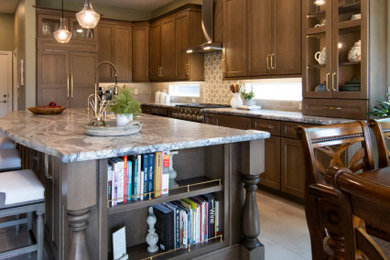 Example of a large classic l-shaped porcelain tile and beige floor open concept kitchen design in Phoenix with an undermount sink, shaker cabinets, medium tone wood cabinets, granite countertops, beige backsplash, porcelain backsplash, paneled appliances, an island and multicolored countertops