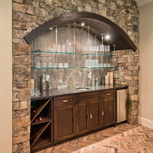 ニューヨークの中サイズのトラディショナルスタイルのおしゃれなウェットバー (アンダーカウンターシンク、濃色木目調キャビネット、御影石カウンター、グレーのキッチンパネル、レンガの床、落し込みパネル扉のキャビネット) の写真