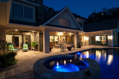 Inspiration for a large transitional backyard stone and rectangular infinity hot tub remodel in Charlotte