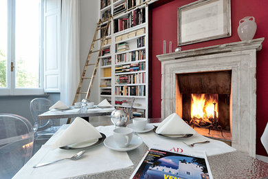 Foto di una sala da pranzo minimal con pareti rosse e camino classico