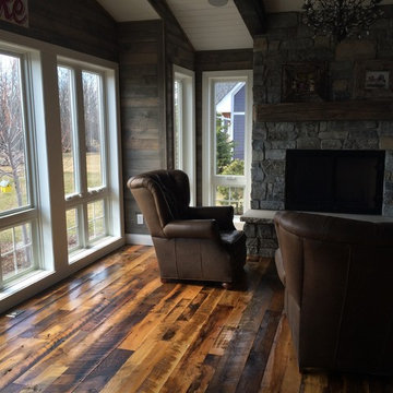 Reclaimed Mixed Hardwood Flooring in a Sunroom with Stone Fireplace