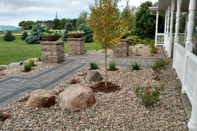 This is an example of a contemporary full sun front yard brick landscaping in Other for summer.