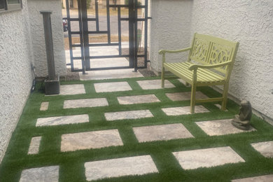 After installation of artificial turf between travertine pavers