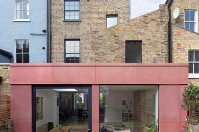 Große, Vierstöckige Moderne Doppelhaushälfte mit Betonfassade, pinker Fassadenfarbe und Flachdach in London