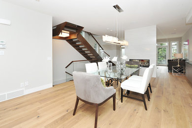 Example of a mid-sized transitional medium tone wood floor great room design in Calgary with white walls and no fireplace