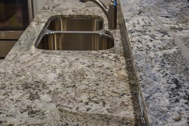 Small transitional u-shaped porcelain tile open concept kitchen photo in Jacksonville with an undermount sink, shaker cabinets, white cabinets, quartz countertops, white backsplash, subway tile backsplash, stainless steel appliances and no island