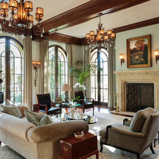 Geräumiges, Fernseherloses, Abgetrenntes Mediterranes Musikzimmer mit grüner Wandfarbe, dunklem Holzboden, Kamin und Kaminsims aus Stein in Los Angeles