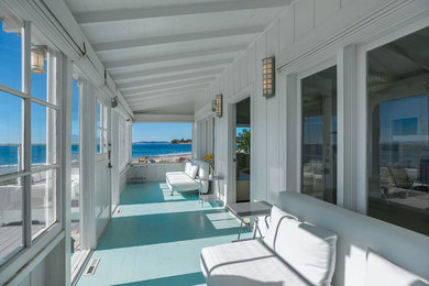 Inspiration for a large coastal backyard deck remodel in Santa Barbara with a roof extension