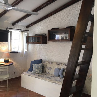 Imagen de salón mediterráneo, pequeño, con paredes blancas y televisor colgado en la pared